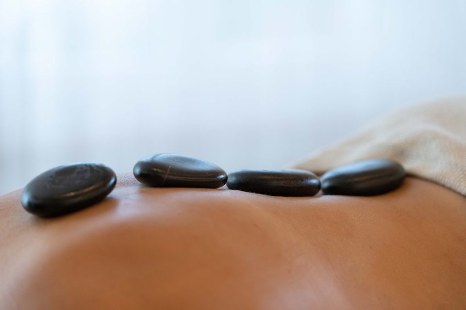 Warme Basaltsteine auf dem Rücken